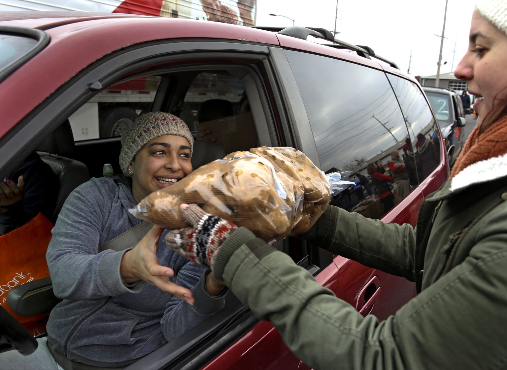 Volunteer hands out food during 'Thanksgiving Together' giveaway